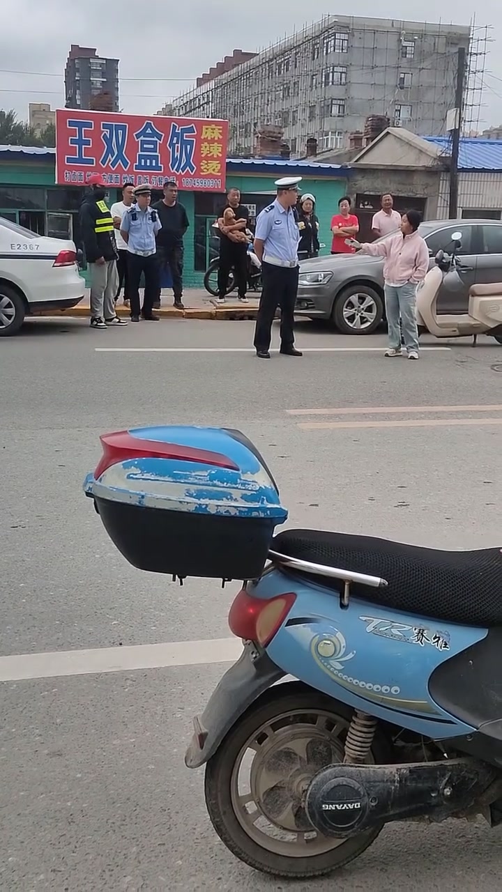 女子骑电摩没戴头盔被查后居然现场摇人!