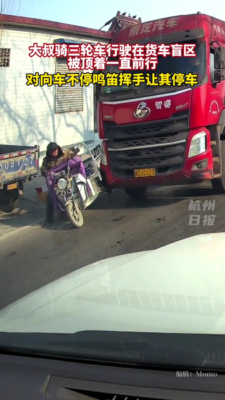 大叔骑三轮车行驶在货车盲区被顶着一直前行!还好停住了