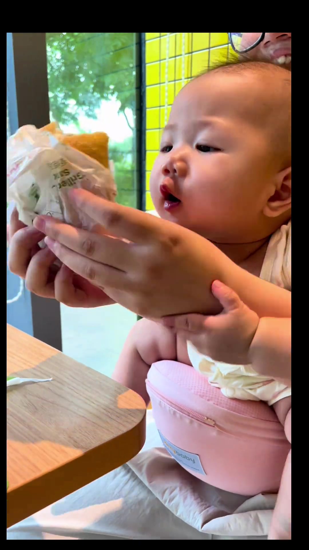 宝贝长大了,知道汉堡烫,帮妈妈吹冷呢!