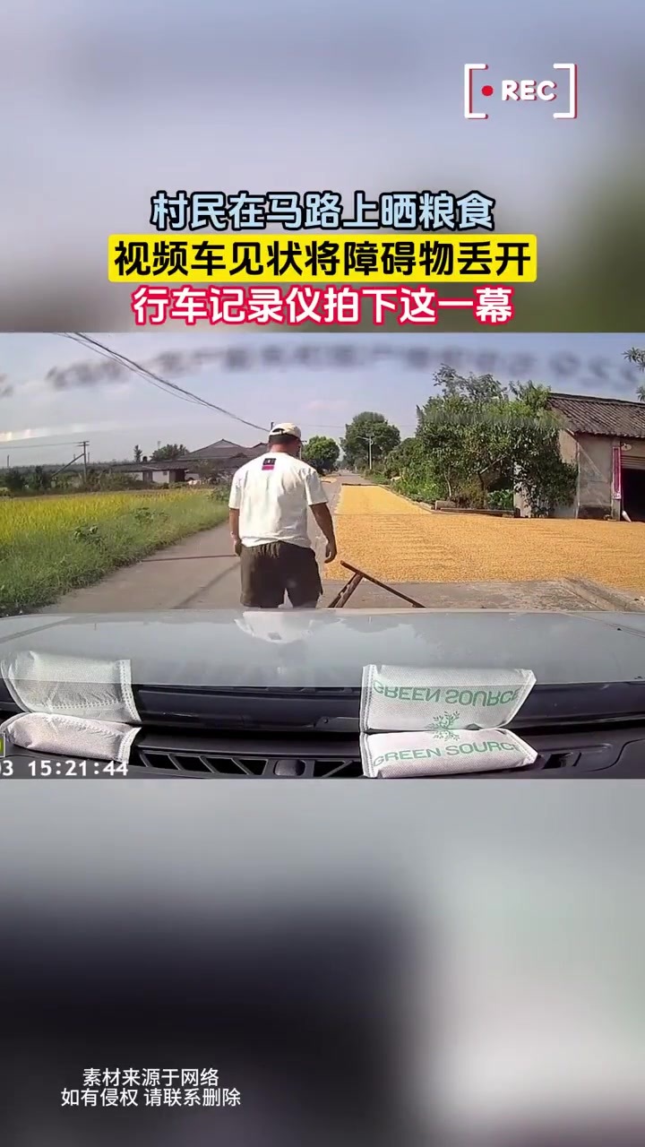 村民在马路上晒粮食视频车见状将障碍物丢开