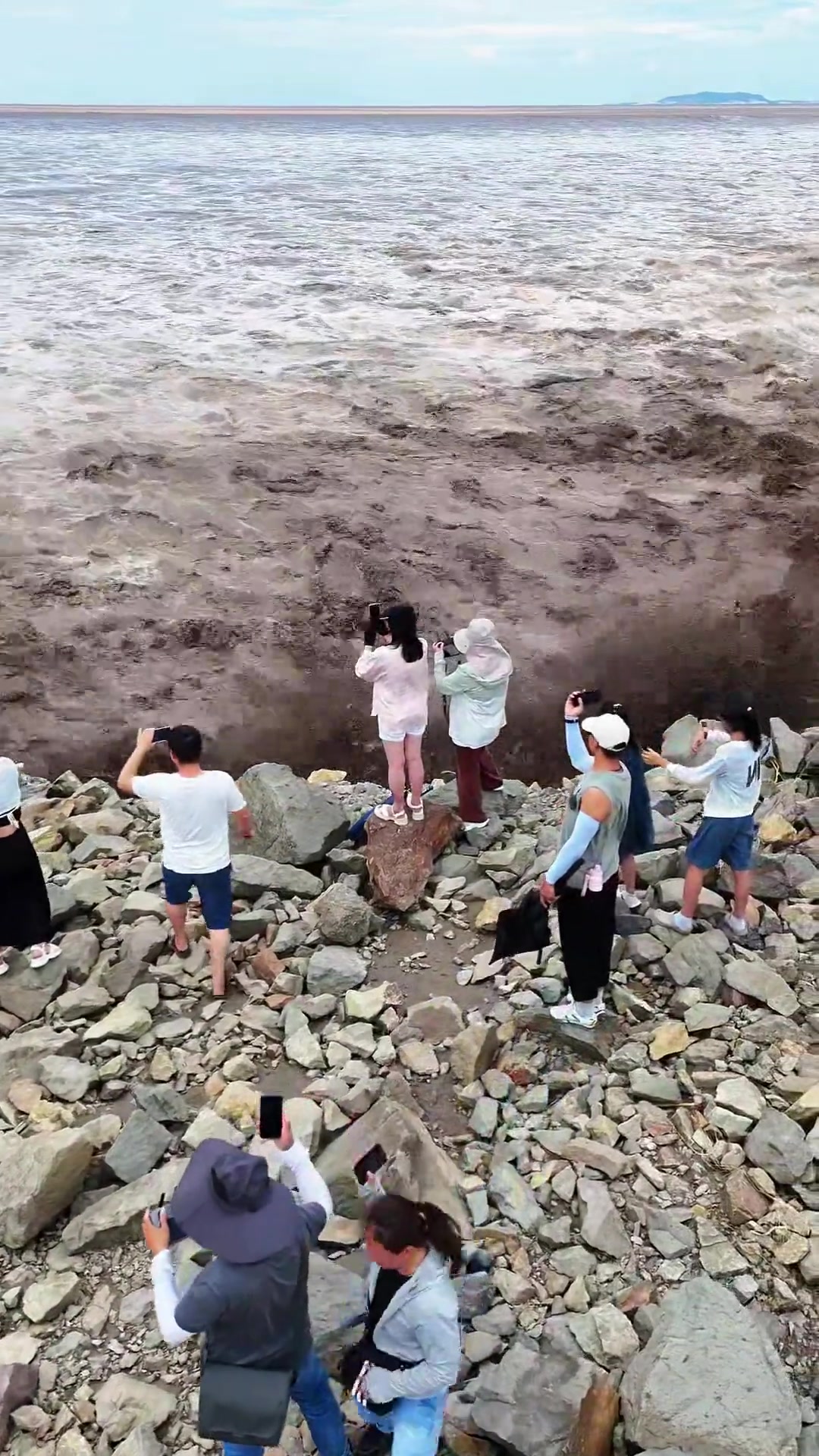大潮冲到脚下了,游客稳如泰山还在拿着手机拍照