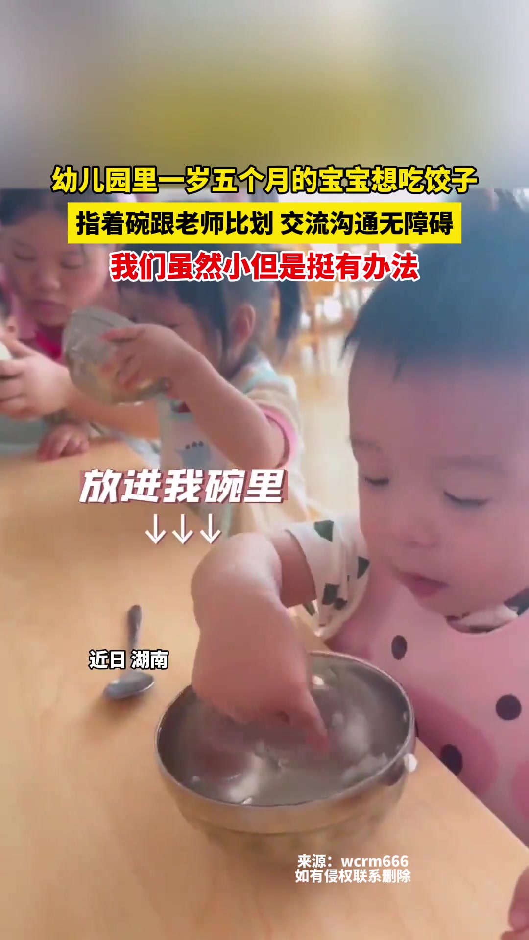 幼儿园里一岁五个月的宝宝想吃饺子,指着碗跟老师比划
