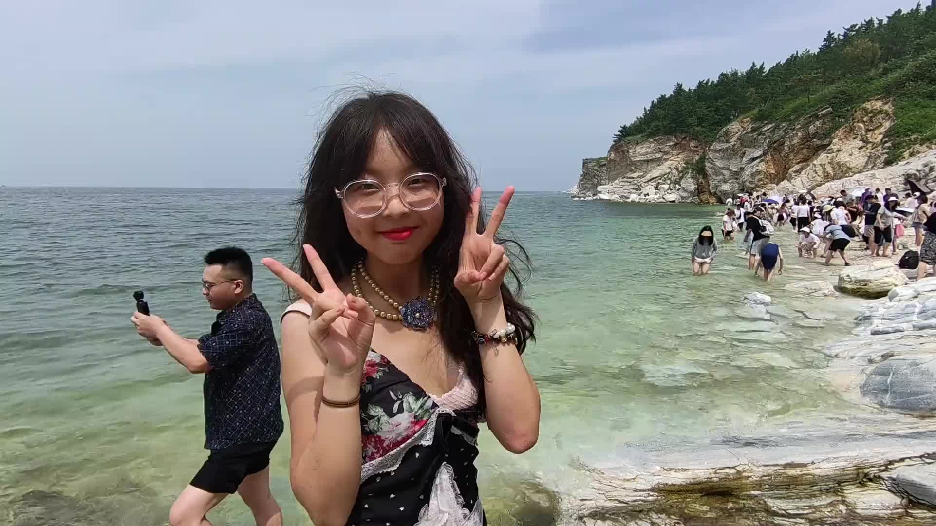 一女生在海边拍照意外摔倒