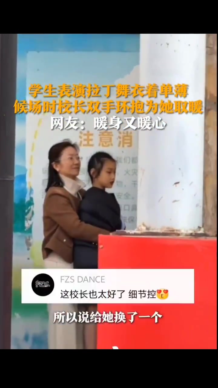 学生表演拉丁舞衣着单薄，候场时校长双手环抱着她取暖