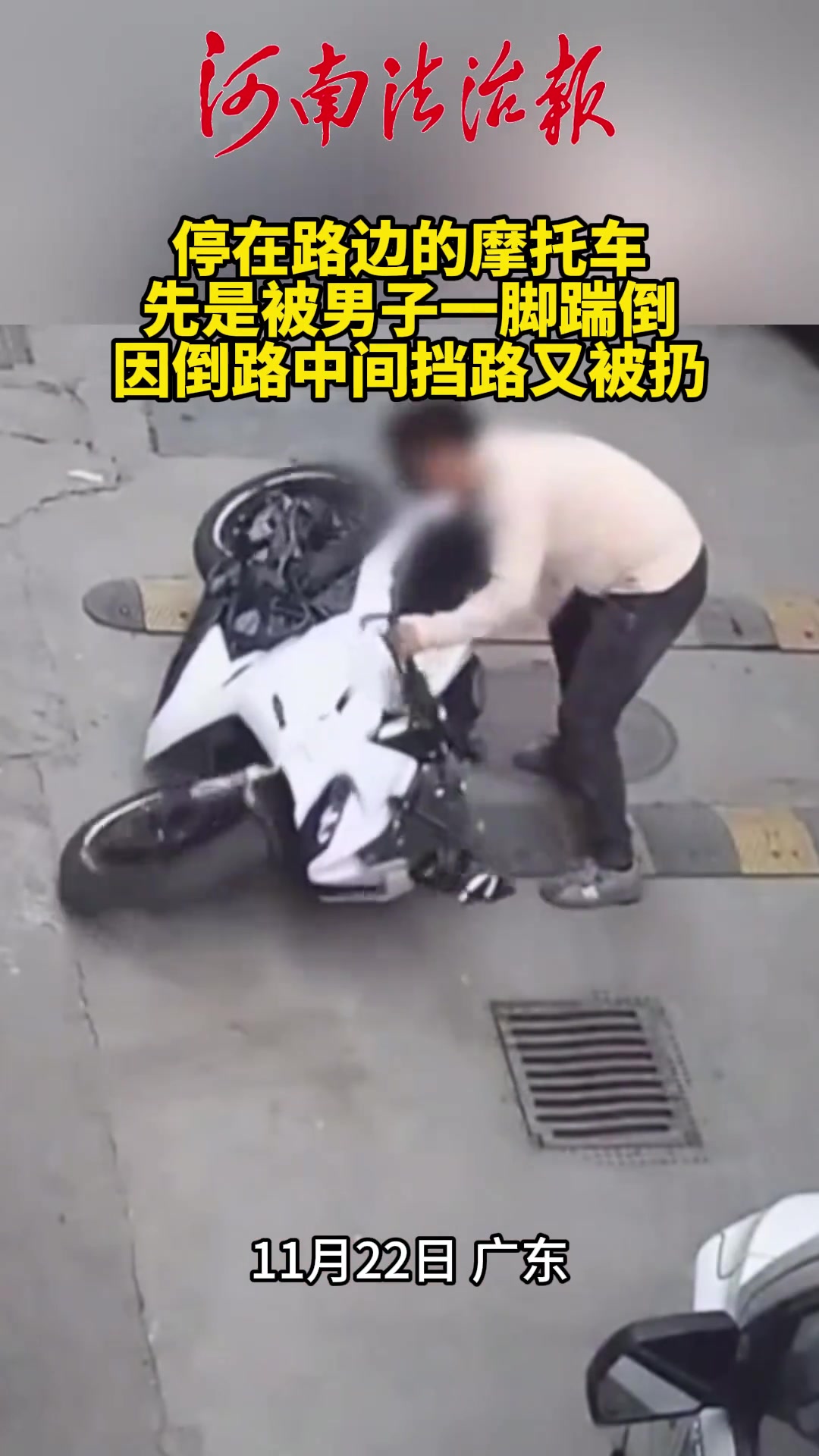 停在路边的摩托车，先是被男子一脚踹倒，因倒路中间挡路又被扔
