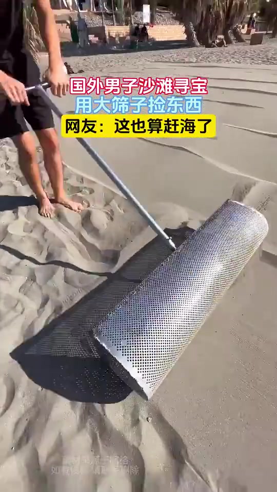 国外男子沙滩寻宝，用大筛子捡东西，网友：这也算赶海了