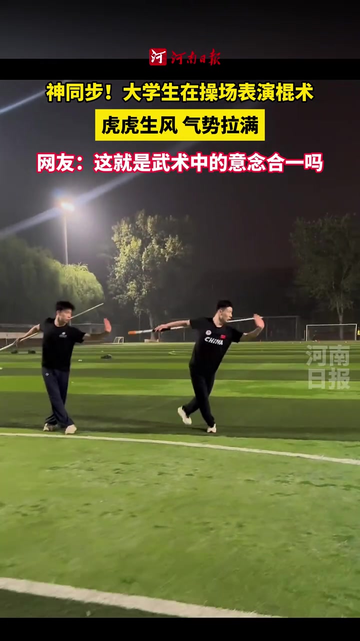 大学生在操场上表演棍术，两人动作神同步，虎虎生风