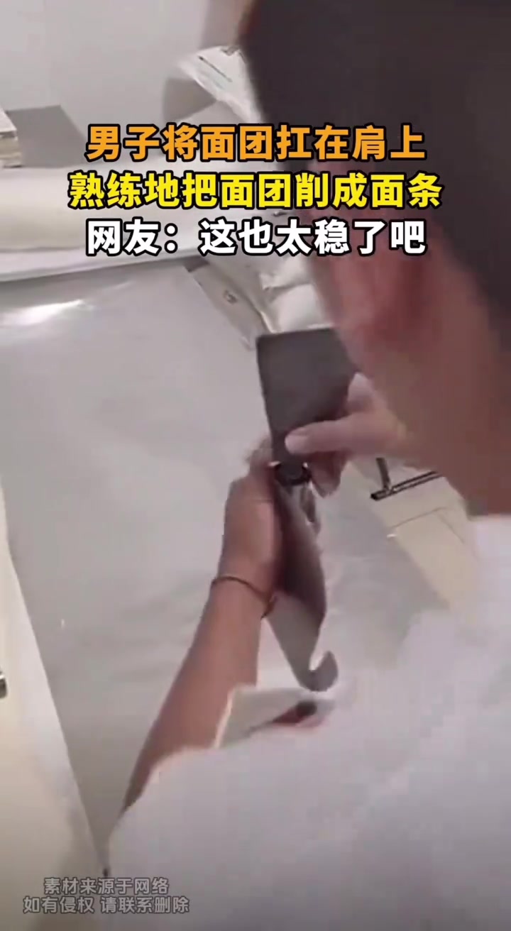 男子将面团抗在肩上，熟练的把面团削成面条