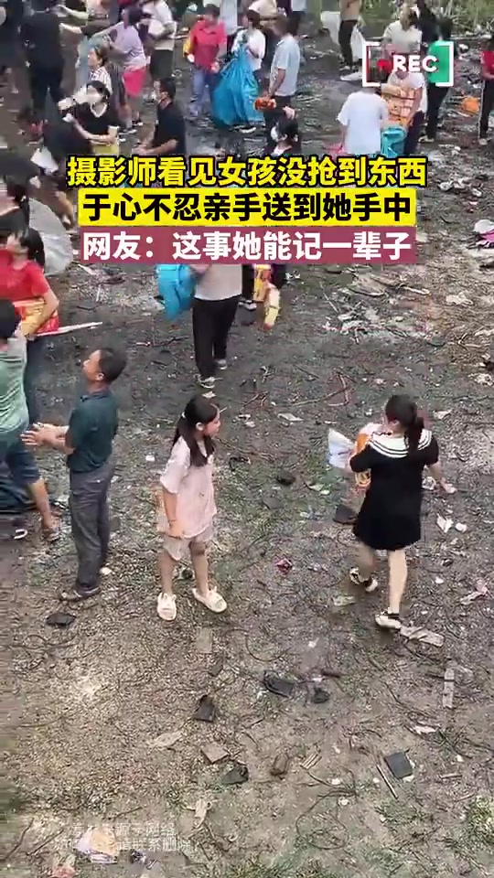 摄影师看见女孩没抢到东西，于心不忍亲手送到她手中