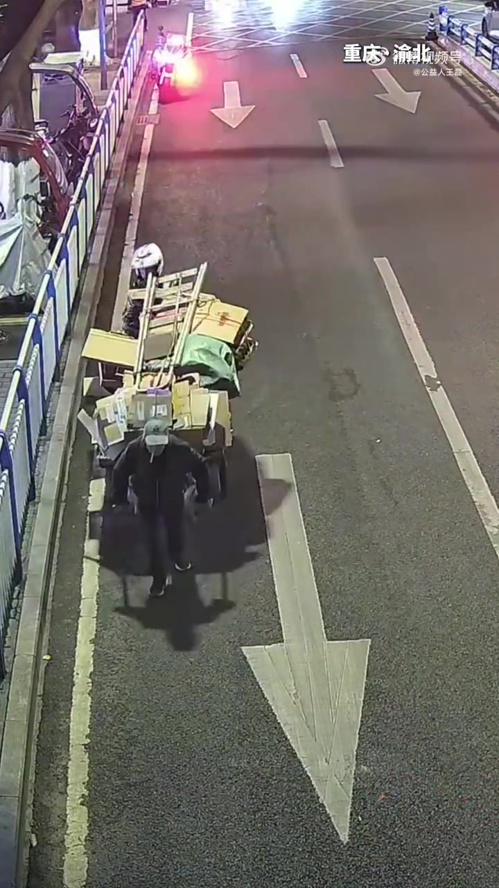 老人拉着装满纸板的平板车吃力上坡，巡逻交警帮忙推车并加固货物