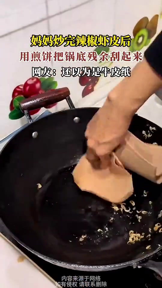 妈妈炒完辣椒虾皮后，用煎饼把锅底残余刮起来