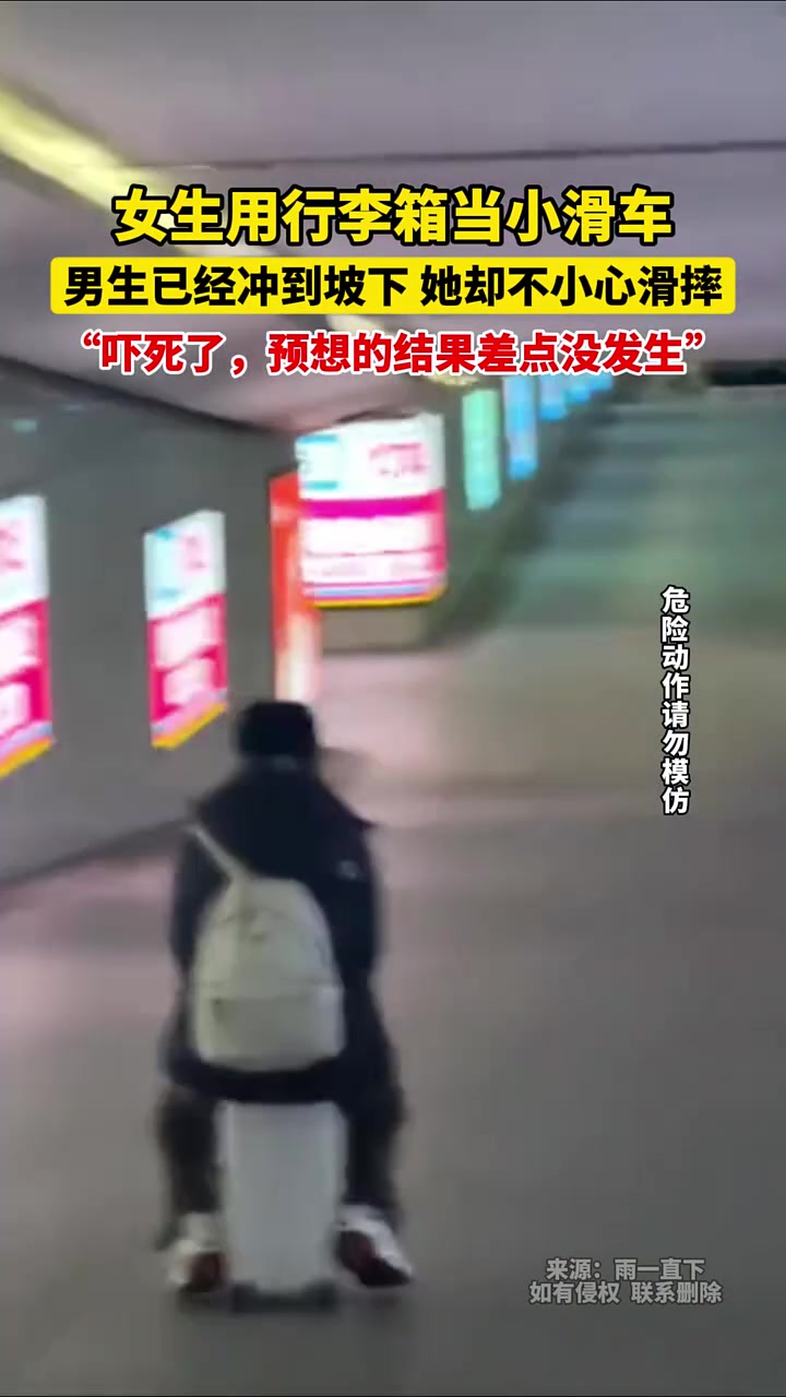 女生用行李箱当小滑车，男生已经冲到坡下，她却不小心滑摔