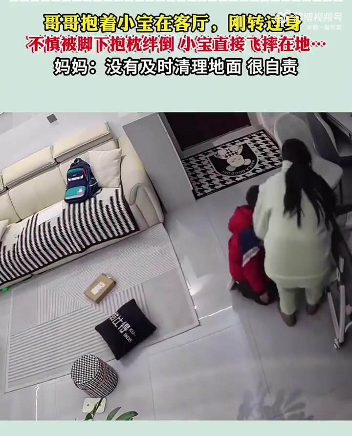 哥哥抱着小宝在客厅不慎被脚下抱枕绊倒，哥哥十分自责！
