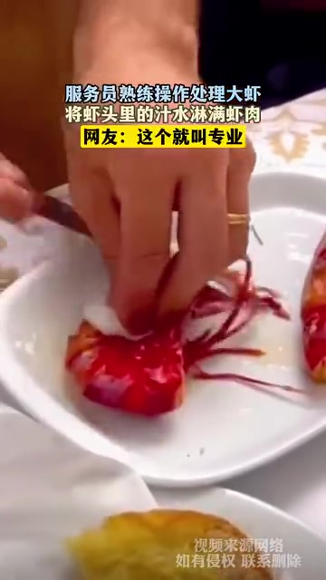 服务员熟练操作处理大虾，将虾头里的汁水淋满虾肉