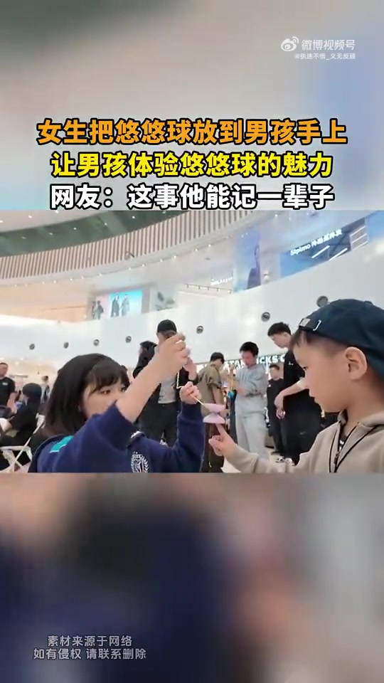 女生把悠悠球放到男孩手上，让男孩体验悠悠球的魅力