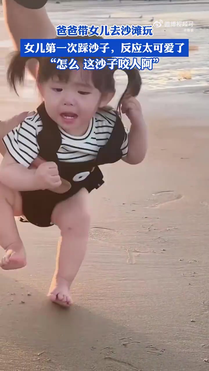 爸爸带女儿去沙滩玩，女儿第一次踩沙子，反应太可爱了萌娃