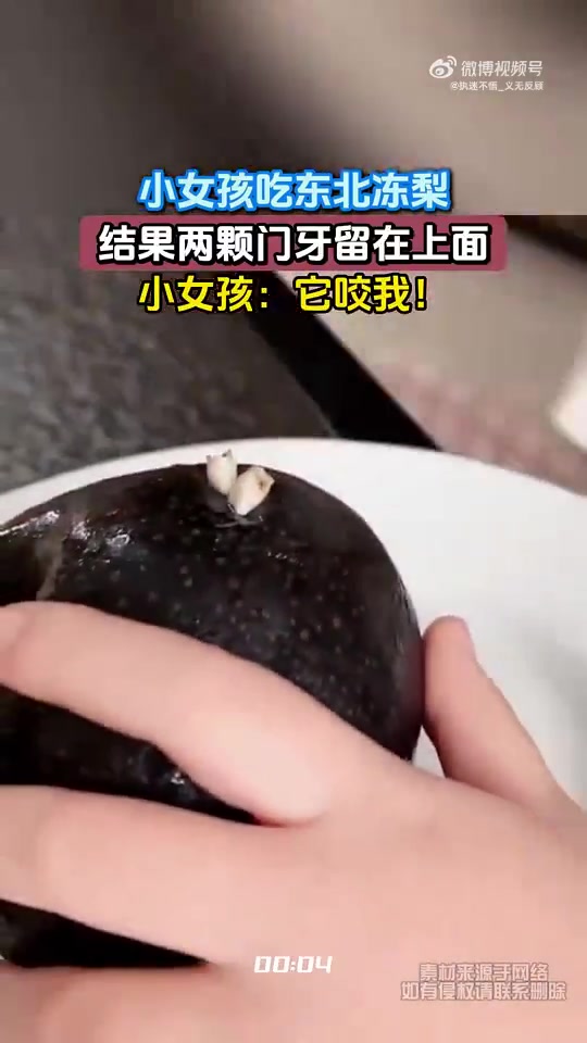 小女孩吃东北冻梨，结果两颗门牙留在上面，小女孩：它咬我！