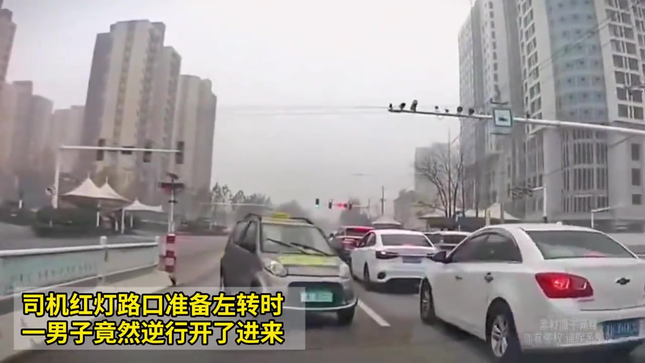 司机红灯路口准备左转时，一男子竟然逆行开了进来！
