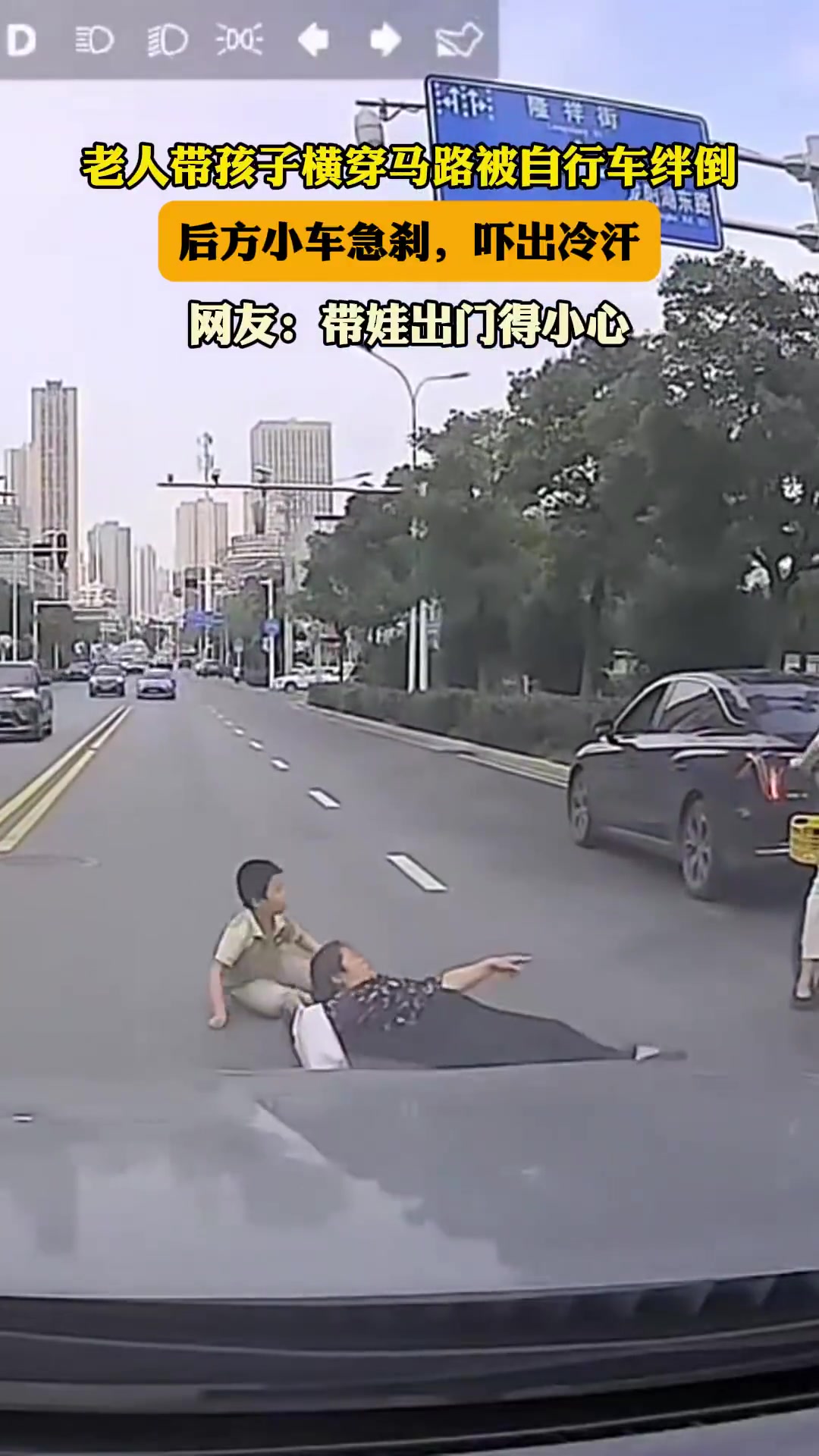 老人带孩子横穿马路被自行车绊倒，后方小车急刹，吓出冷汗！