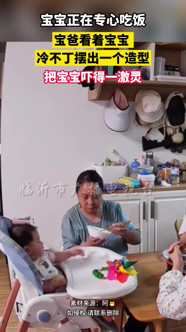 宝宝正在专心吃饭，宝爸看着宝宝冷不丁摆出一个造型