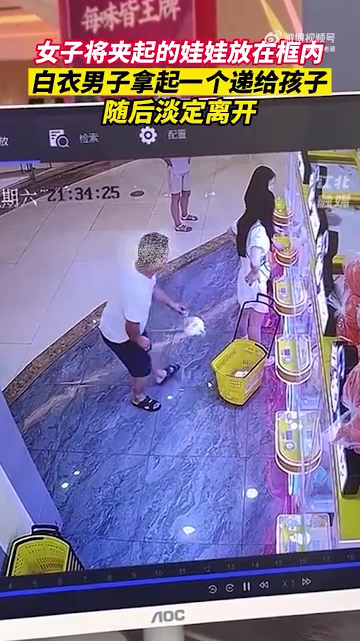 這不就是偷竊嗎男子將女子放在框里的娃娃拿起一個(gè)遞給孩子??！