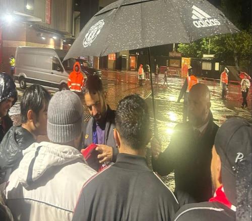 尽管冒着大雨，阿莫林赛后还是停下来给球迷们签名