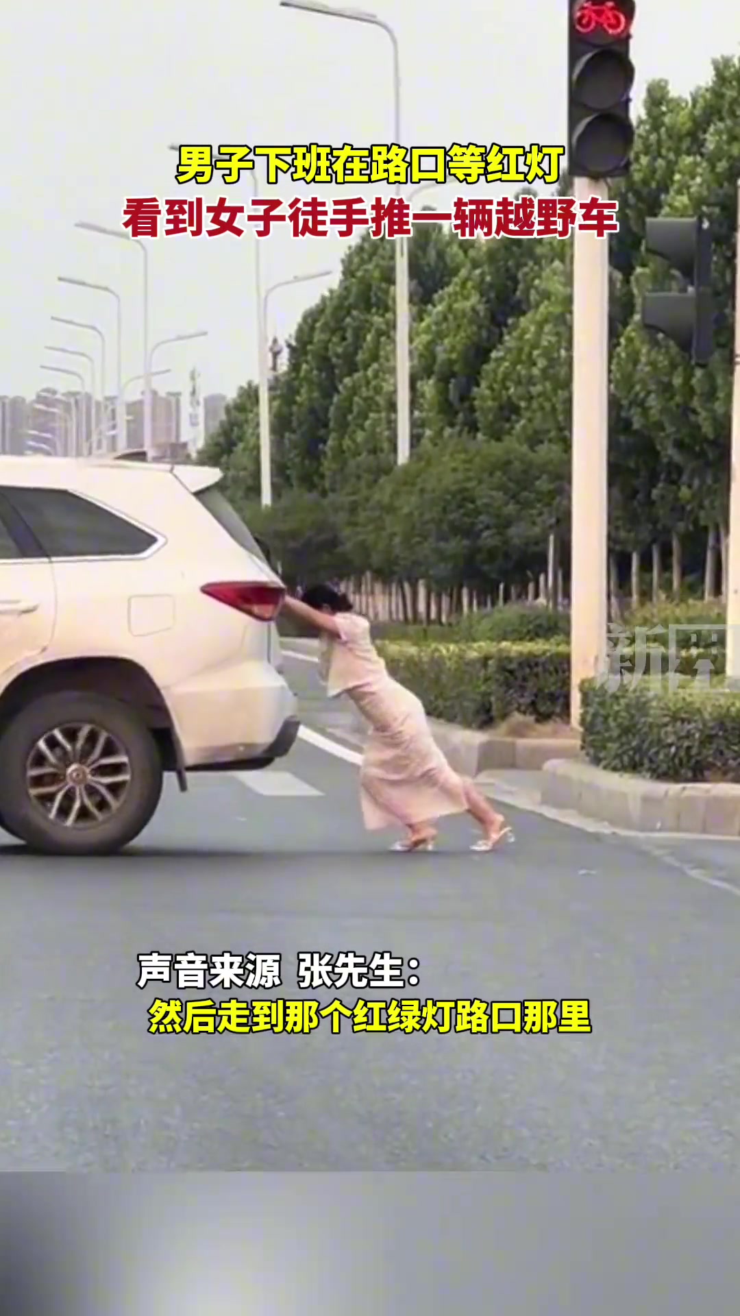男子下班在路口等红灯，看到女子徒手推一辆越野车。