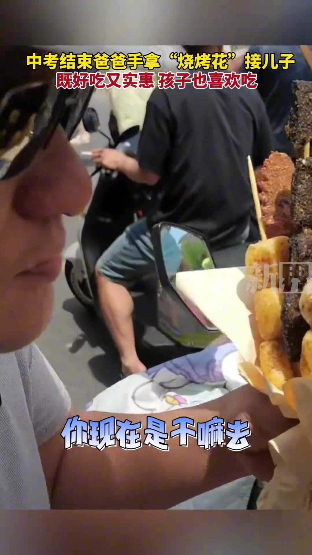 中考结束爸爸手拿“烧烤花”接儿子