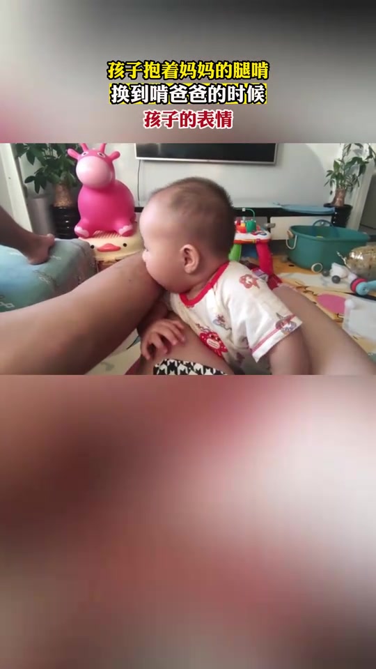 孩子抱着妈妈的腿啃，换到啃爸爸的时候，孩子的表情