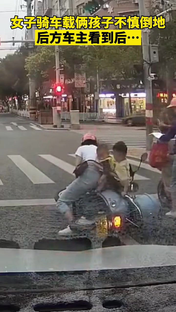 暖心！女子骑车载俩孩子不慎倒地 后方车主看到后…
