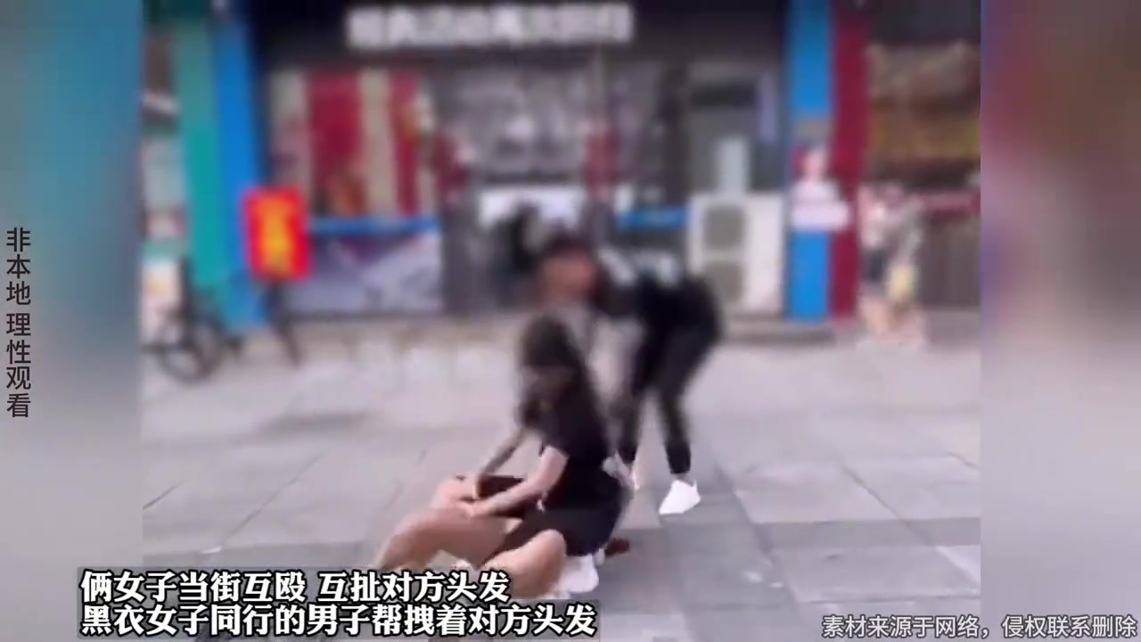 俩女子当街互殴互扯对方头发，黑衣女子同行的男子帮拽着对方头发
