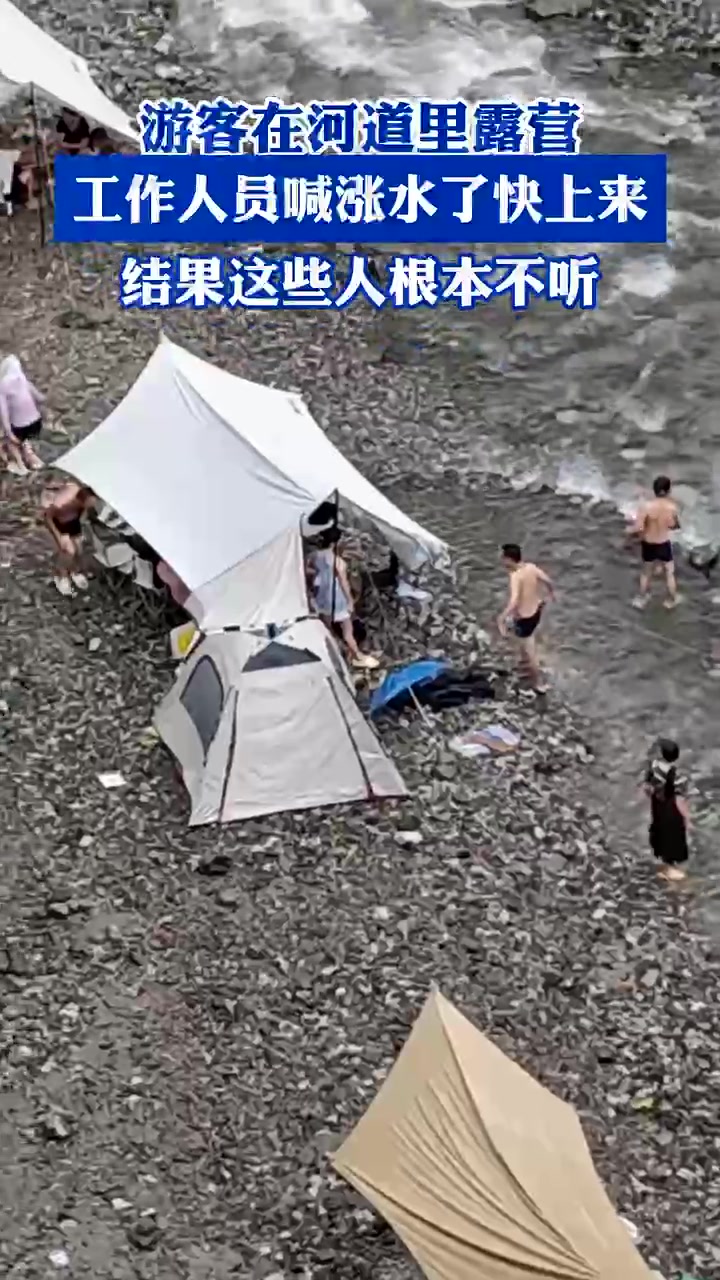 游客在河道里露营，工作人员喊涨水了快上来，结果这些人根本不听