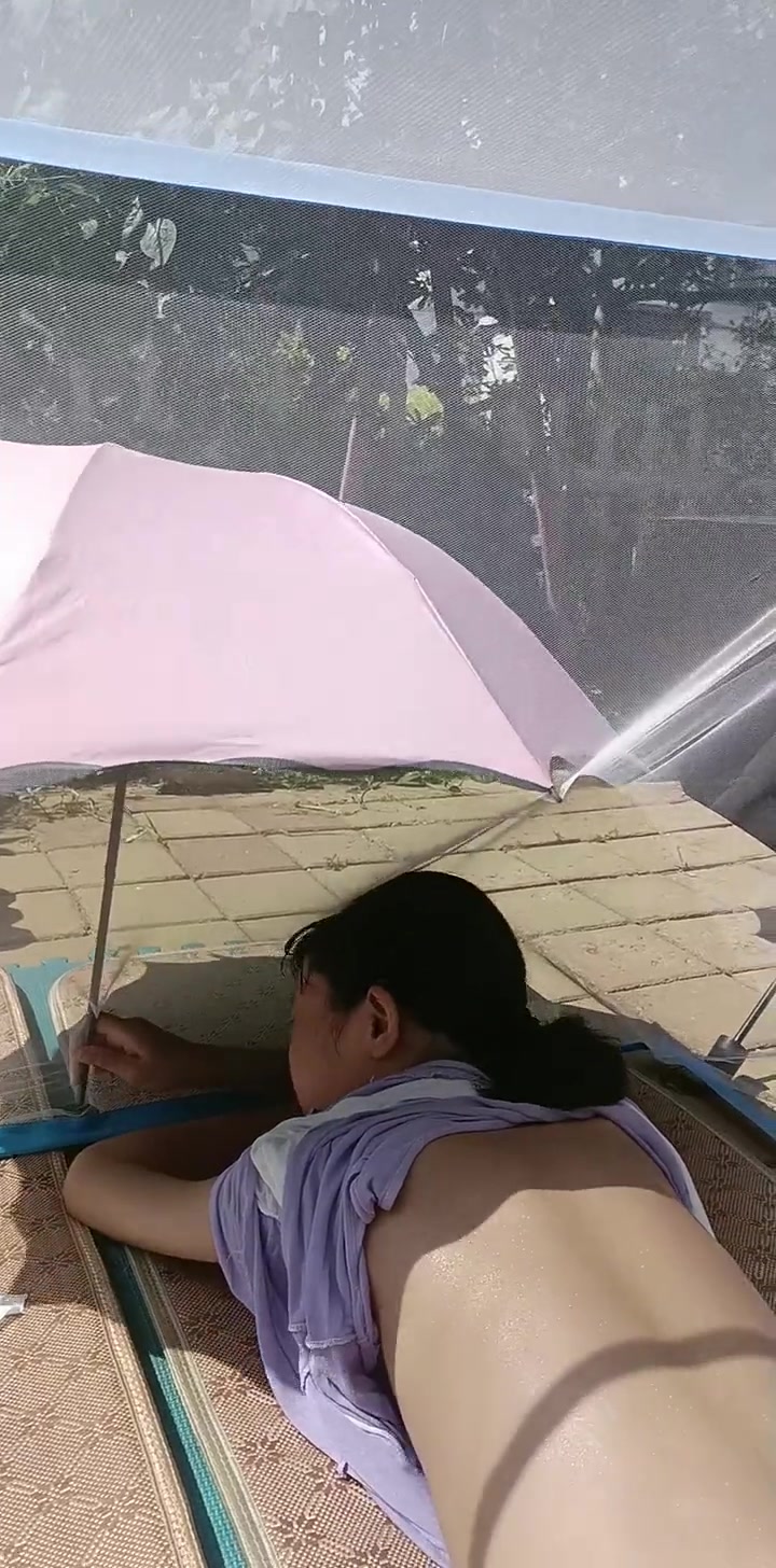 她打着伞遮头，撩衣服晒背，这是什么操作
