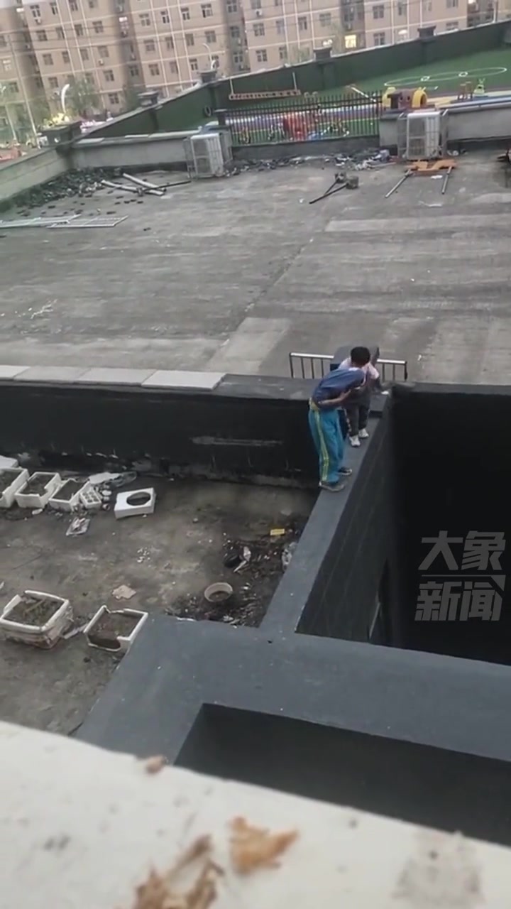 两名小孩在高层楼顶玩耍宛如“走钢丝”看得人心惊胆战