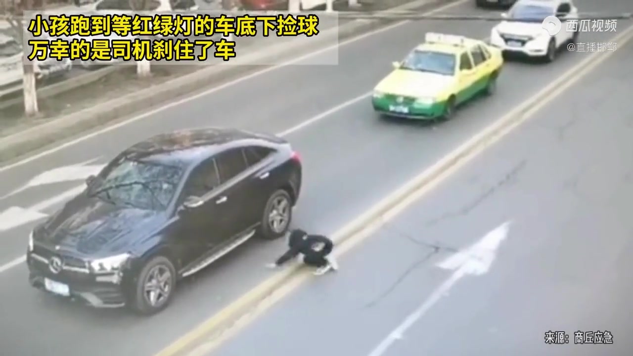 小孩跑到车底下捡球，万幸的是司机刹住了车