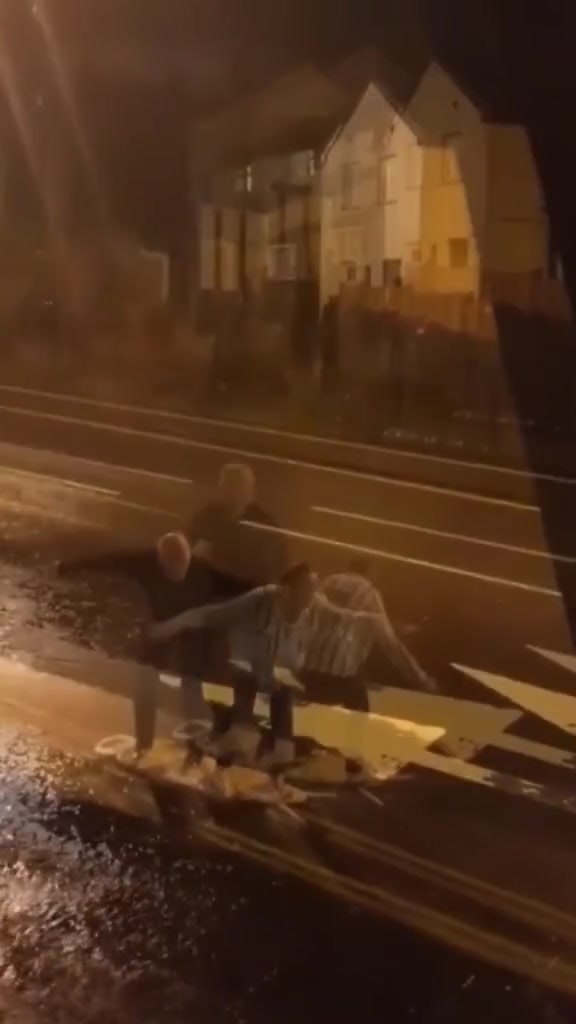 大雨中一对夫妻用烫衣板玩起冲浪其实也挺有意思的