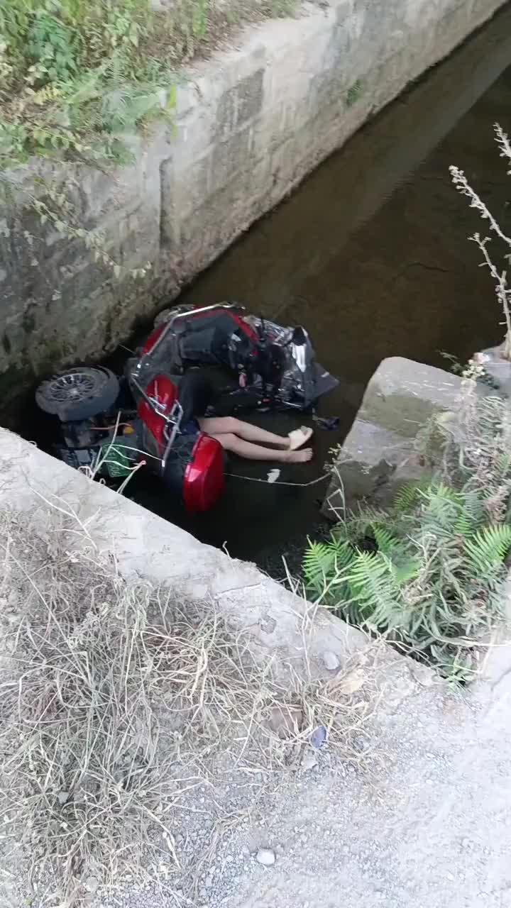 小姐姐骑电动掉进水沟，人还被压在车下！