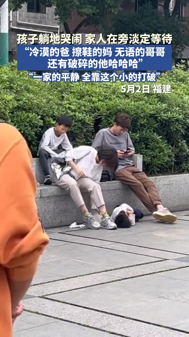 孩子躺地上哭闹，家人在旁边耐心等待
