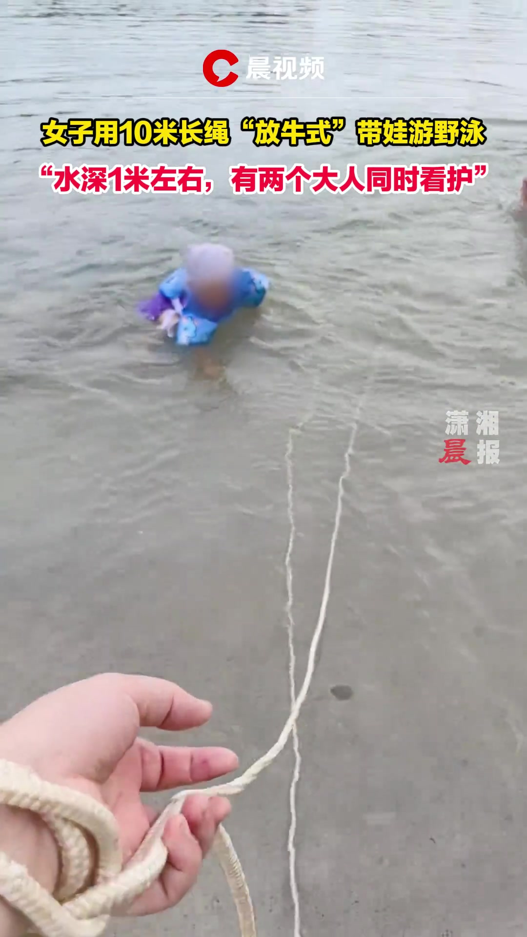女子用10米长绳放牛式带娃游野泳水深1米左右，两个大人同时看护