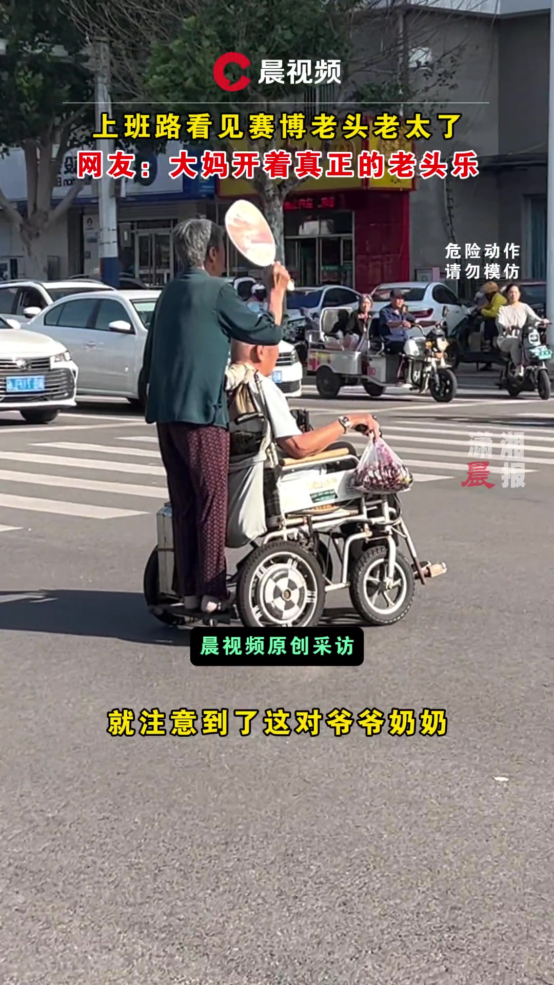 奶奶开着爷爷的电动轮椅行驶过马路