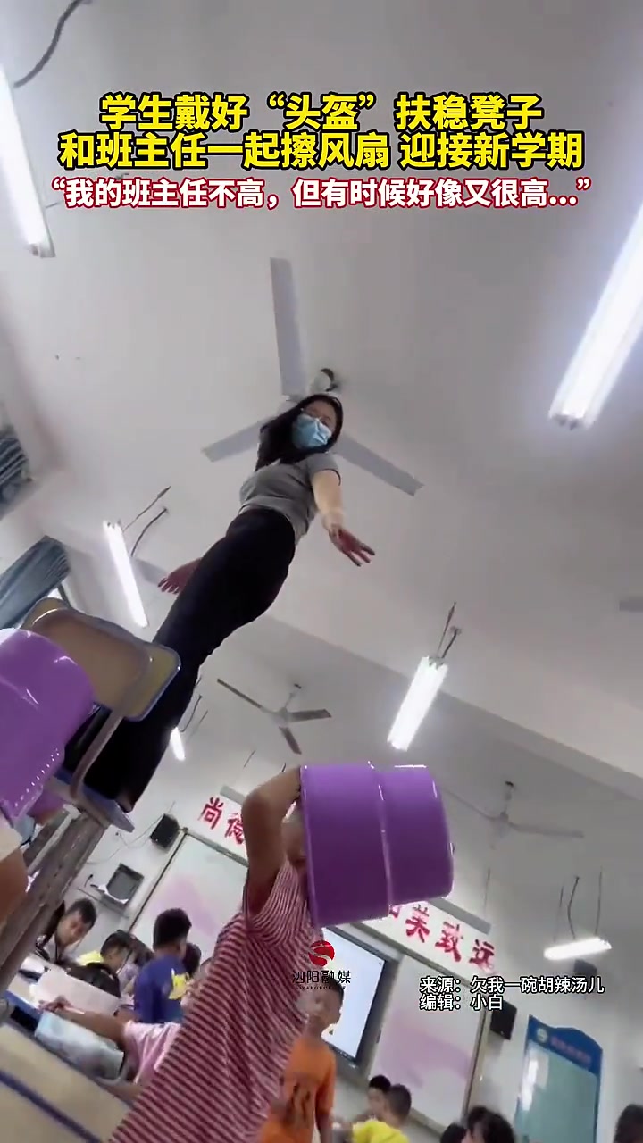 学生们戴好“头盔”和班主任一起擦风扇