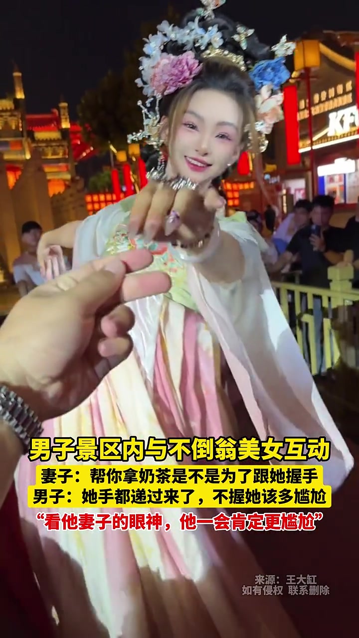 老婆：帮你拿奶茶是不是为了跟她握手！男子景区与不倒翁美女互动