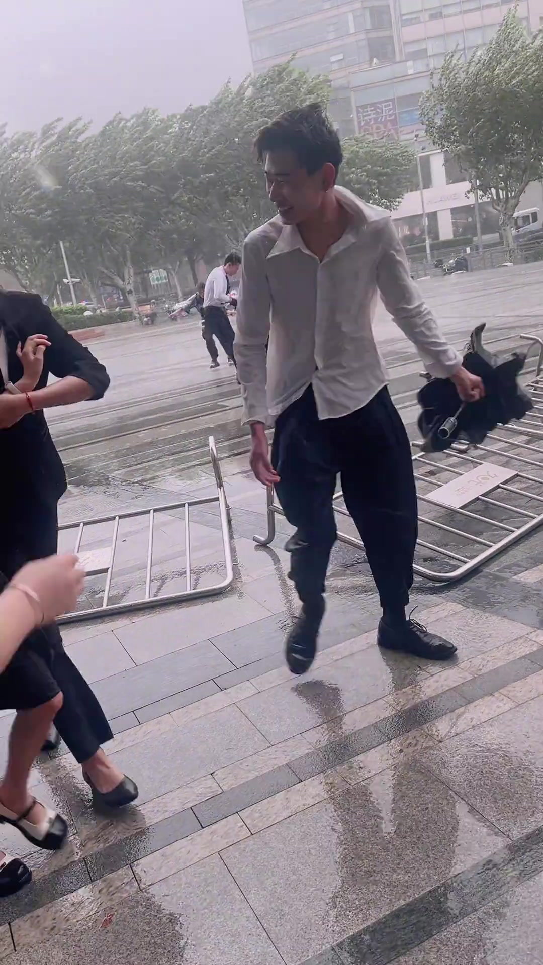 上海刮台风，路过的美女被风刮到，鞋子都飞了
