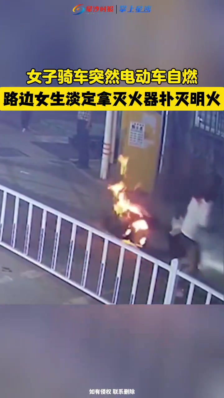 女子骑车突然电动车自燃，路边女生淡定拿灭火器扑灭明火