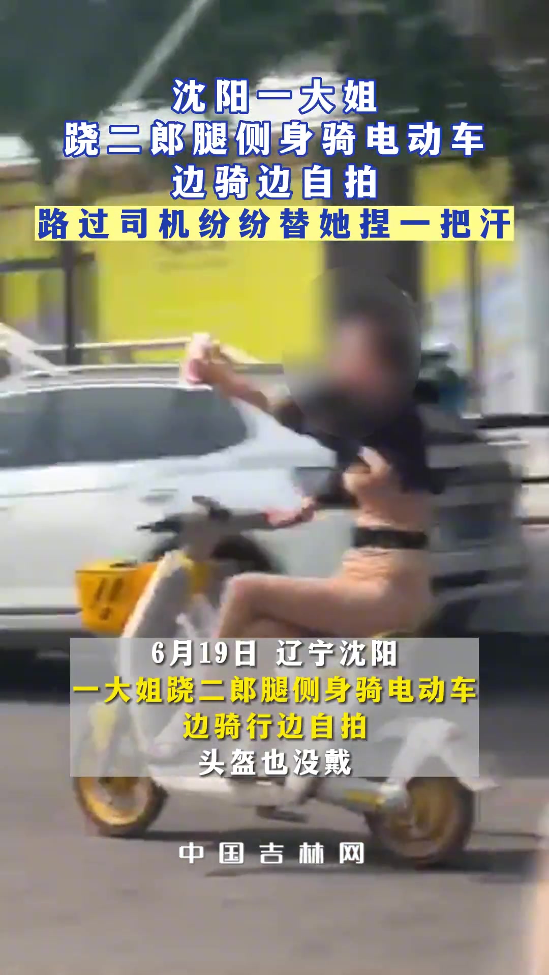 一女子没戴头盔并跷二郎腿侧身骑电动车边骑行边自拍
