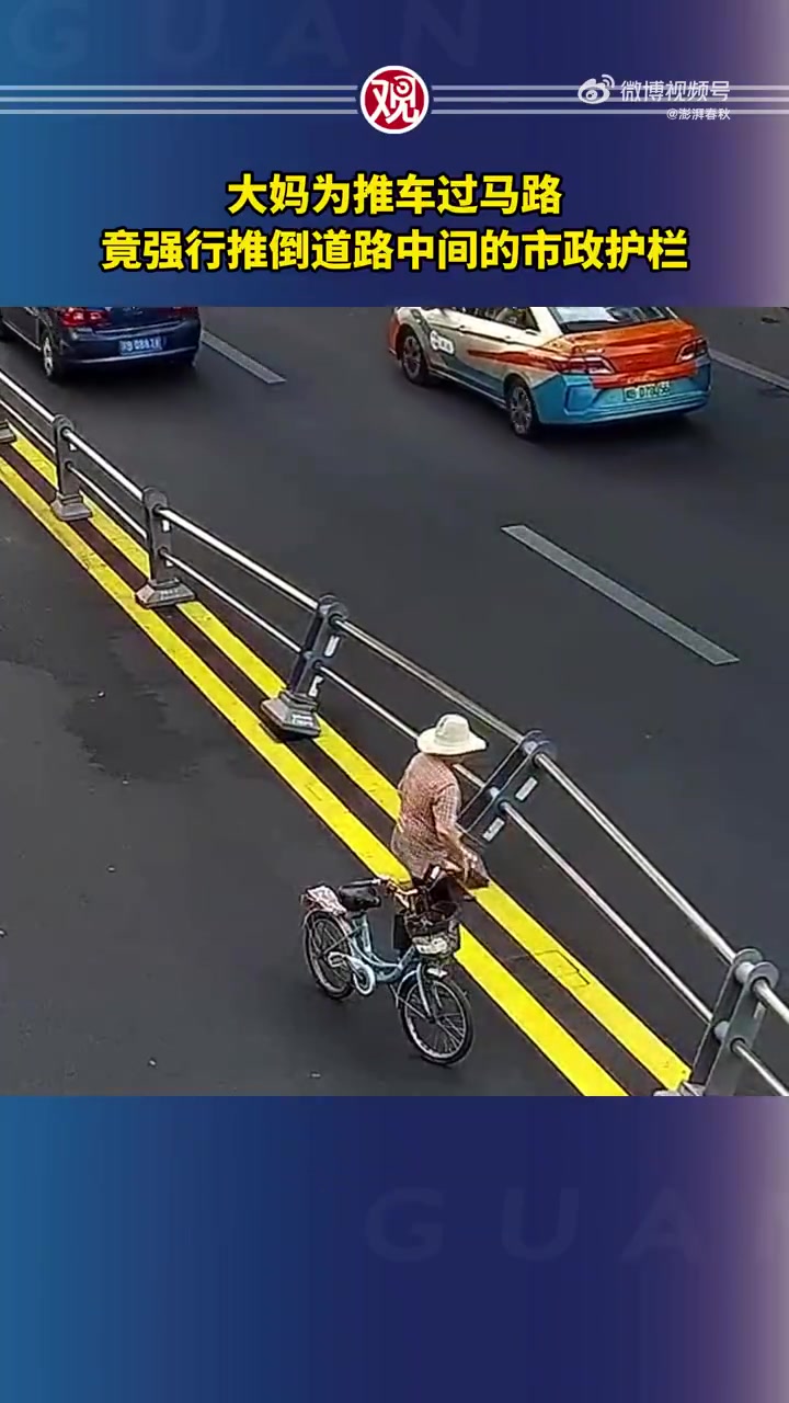 大妈为推车过马路，竟强行推倒道路中间的护栏