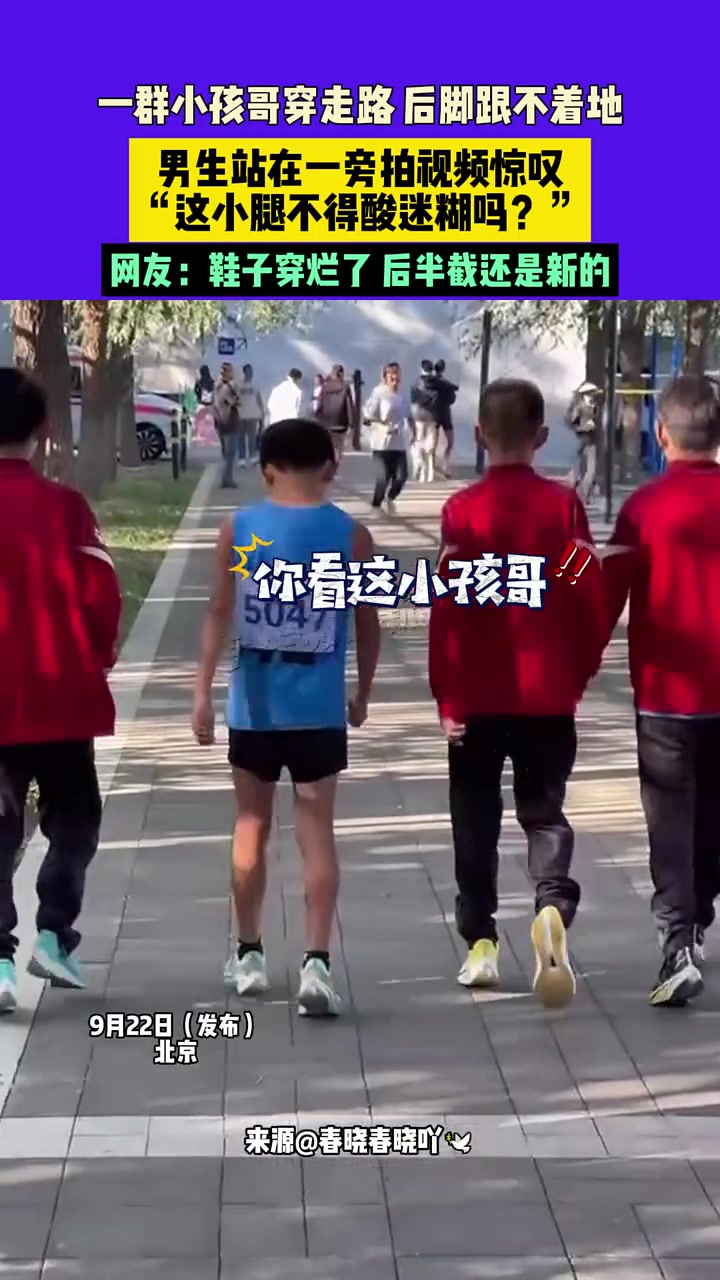 一群小孩哥穿走路后脚跟不着地，男生站在一旁拍视频惊叹