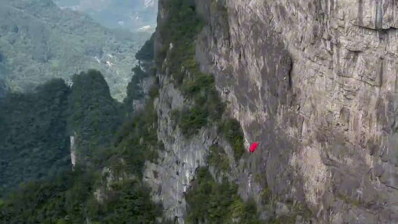 张家界景区爬山时，惊现披着红披风的“超人”从山顶一跃而下