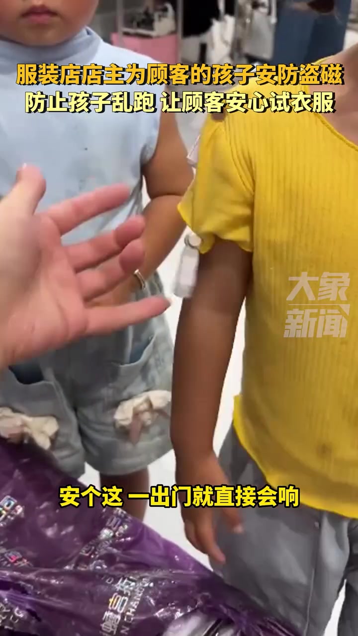 服装店店主为顾客的孩子安防盗磁，防止孩子乱跑！