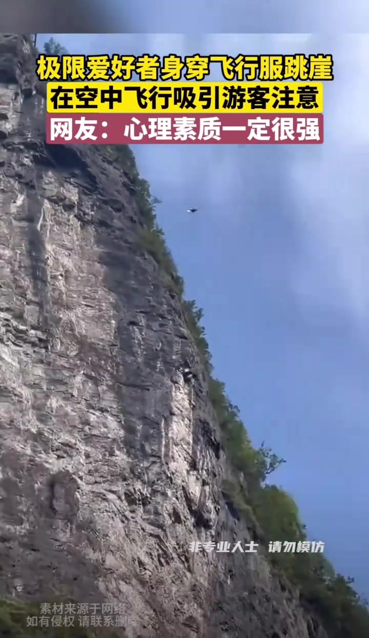 极限爱好者身穿滑翔衣从悬崖跳下，在空中高速飞行下山